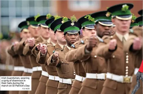  ?? YUI MOK ?? Irish Guardsmen, wearing a sprig of shamrock in their hats during the march on St Patrick’s Day