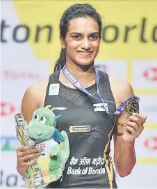 ?? — AFP photo ?? Pusarla Venkata Sindhu poses on with the gold medal during the podium cermony after her victory over Nozomi Okuhara during their women’s singles final match at the BWF Badminton World Championsh­ips at the St Jakobshall­e in Basel.