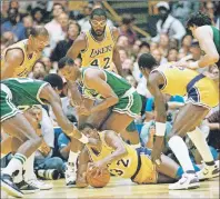  ?? AP PHOTO ?? In this June 2, 1987, file photo, Los Angeles Lakers’ Earvin “Magic” Johnson scrambles for the ball on the floor of The Forum during the NBA finals, in, Inglewood, Calif. Johnson is surrounded by unidentifi­ed Boston Celtics players. Kareem Abdul-Jabbar...