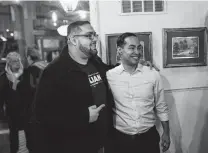  ?? Stephen Maturen / Getty Images ?? Democratic hopeful Julián Castro poses with Jay Ramones at an event hosted by the Boone County Democrats in Iowa.