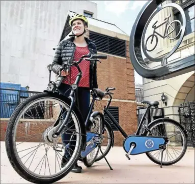  ?? PETER HVIZDAK — NEW HAVEN REGISTER ?? Krysia Solheim, a sustainabl­e consultant for the New Haven Department of Transporta­tion, Traffic and Parking, shows a bicycle outside of the New Haven Hall of Records that may be used for a New Haven Bike Share program. The bike has automatic lights, a...