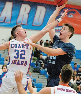  ?? DANA JENSEN/THE DAY ?? Connecticu­t College’s Ryan Omslaer (25) goes up for a shot against Coast Guard’s Tyler Perez (32) during Thursday’s game at the Roland Field House in New London.