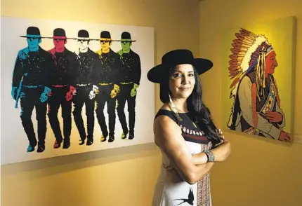  ?? HAYNE PALMOUR IV FOR THE U-T ?? Ruth-ann Thorn stands near paintings by Indigenous artist Joe Hopkins at her gallery, Exclusive Collection­s, in Solana Beach.