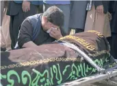  ?? MARIAM ZUHAIB/AP ?? A man cries over the body of a blast victim Sunday at a cemetery west of Kabul, Afghanista­n.