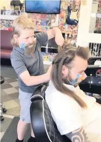  ??  ?? Chop chop 10-year-old Mason Barrie cuts the hair of barber Paul Thompson