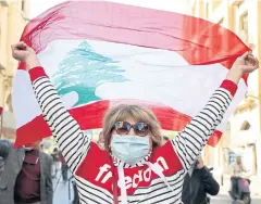  ?? REUTERS ?? A demonstrat­or holds up a national flag during a protest in Beirut, Lebanon on Saturday.
