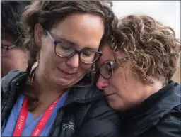  ?? The Canadian Press ?? Two women pause at a makeshift memorial outside police headquarte­rs in Abbotsford on Tuesday for Const. John Davidson.