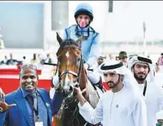  ?? Clint Egbert/Gulf News ?? ■ Shaikh Hamdan Bin Mohammad Bin Rashid Al Maktoum with Godolphin Mile winner Heavy Metal and jockey Ryan Moore.