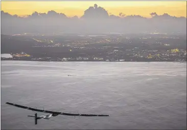  ?? JEAN REVILLARD/ASSOCIATED PRESS ?? The Solar Impulse 2, a plane powered by the sun’s rays, approaches Kalaeloa Airport outside Honolulu on Friday. The nearly 118-hour voyage from Nagoya, Japan, broke the record for the world’s longest nonstop solo flight, organizers said..