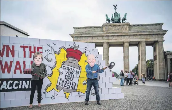  ?? Photo: Stefanie Loos/afp/getty Images ?? Blocked: Avaaz activists wear masks of German Chancellor Angela Merkel and United States President Joe Biden in a ‘Tear Down the Patent Wall’ and ‘Free the Vaccine’ protest as Germany blocks a World Trade Organisati­on waiver for Covid-19 vaccines.