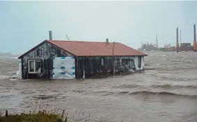  ?? Peggy Fagerstrom/Associated Press ?? A home floats in the Snake River near Nome, Alaska, as the state’s western coast gets pounded by the remnants of Typhoon Merbok.
