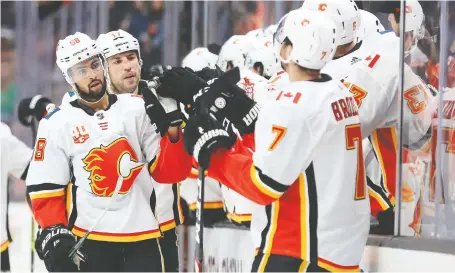  ?? SEAN M. HAFFEY/GETTY IMAGES ?? Calgary defenceman Oliver Kylington is congratula­ted at the bench after scoring in the first period to give the Flames an early 3-0 lead over the Ducks on Thursday night at the Honda Center in Anaheim. The Flames sailed to a 6-0 victory.