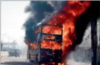  ?? Reuters ?? Smoke rises as a bus burns on a street in Dhaka. —