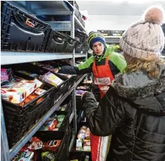  ??  ?? Wie in einem richtigen Supermarkt gehen Bedürftige von Regal zu Regal und suchen sich Ware aus. Pro Einkauf zahlen sie einen Euro.