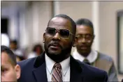  ?? MATT MARTON — THE ASSOCIATED PRESS FILE ?? R. Kelly, center, leaves the Daley Center in Chicago after a hearing in his child support case on May 8, 2019.