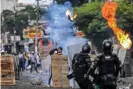  ?? Photograph: Paola Mafla/AFP/Getty Images ?? Demonstrat­ors and riot police clash in Cali, Colombia, on 29 April.