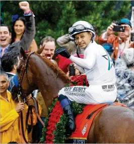  ?? ANDY LYONS / GETTY IMAGES ?? Jockey Mike Smith smiles in the winner’s circle atop Justify after winning the 144th running of the Kentucky Derby at Churchill Downs on Saturday. Justify will run in the Preakness Stakes on May 19.