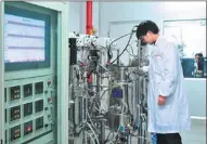  ??  ?? A technician performs experiment­s at a lab of a biotechnol­ogy company in Zhangjiang.