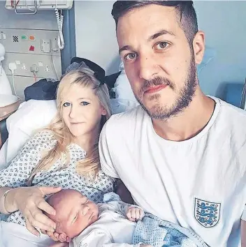  ??  ?? El pequeño Charlie, con sus padres, en una foto previa a su internamie­nto hospitalar­io.