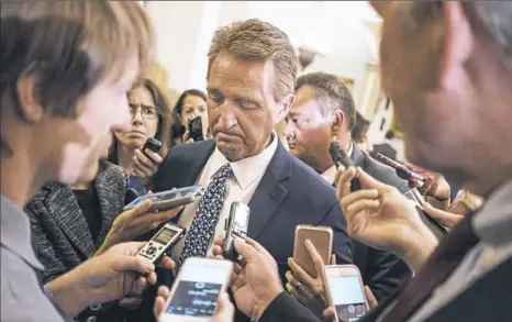  ??  ?? Sen. Jeff Flake, R-Ariz., speaks with reporters Tuesday on Capitol Hill. Senate Majority Leader Mitch McConnell, R-Ky., has announced a hearing Monday for Judge Brett Kavanaugh and his accuser, Christine Blasey Ford.