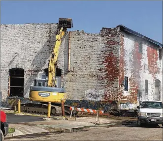  ??  ?? Emergency demolition has started on the warehouse at Bainbridge and Bacon streets that was set on fire in downtown Dayton on Saturday. Two juveniles have been arrested and charged.