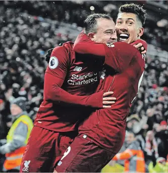  ?? RUI VIEIRA THE ASSOCIATED PRESS ?? Liverpool’s Xherdan Shaqiri, left, celebrates with teammate Roberto Firmino after scoring his side’s third goal during an English Premier League soccer match against Manchester United on Sunday. Liverpool won, 3-1.