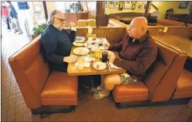  ?? Al Seib Los Angeles Times ?? CANTER’S regulars Kelly Cox, left, and Rick Ingold have breakfast Monday. The county has progressed into the state’s second-most restrictiv­e tier for reopening.