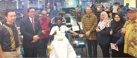  ?? ?? Yaakub (second left) and Kadir (fourth right) cheering on a person donating blood during the campaign.