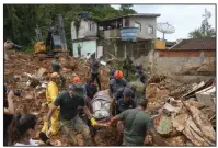  ?? (AP/Andre Penner) ?? Rescue workers, including military and volunteers, carry the body of a victim Feb. 22 near Barra do Sahi beach after a mudslide triggered by heavy rains in the coastal city of Sao Sebastiao, Brazil.