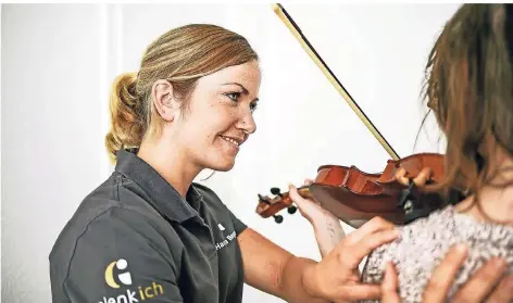  ?? FOTO: LARS FRÖHLICH ?? Physiother­apeutin Hanna Berger erklärt, wie sich die Haltung bei Musikern auf deren Muskulatur auswirkt, beispielsw­eise beim Violinensp­iel.