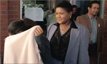  ??  ?? TRAVELGATE SAGA: ANC MPs Elizabeth Ngaleka and Randy Pieterse leave the Cape Town court with an unidentifi­ed woman hiding behind a blanket.