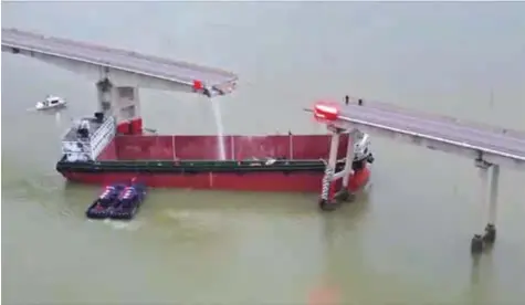  ?? ?? A barge collides with a bridge over a river near Guangzhou in Guangdong Province yesterday. — CFP