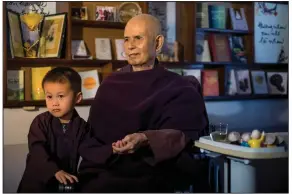  ?? (Linh Pham/The New York Times) ?? Thich Nhat Hanh sits with a child of one of his followers at Tu Hieu Temple in Hue, Vietnam, March 26, 2019. Thich Nhat Hanh, a monk with global influence and an ally of Martin Luther King, who championed what he called “engaged Buddhism” in pressing for peace, died on Saturday at the Tu Hieu Temple.