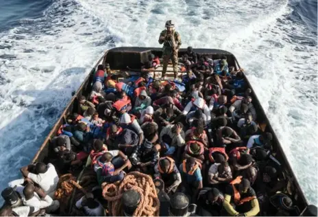  ?? AFP/GETTY IMAGES ?? A Libyan coast guard watches over 147 illegal immigrants attempting to reach Europe. More than 8,000 migrants have been rescued in waters off Libya during the past 48 hours in difficult weather conditions, Italy’s coast guard said on June 27.