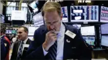 ?? RICHARD DREW — THE ASSOCIATED PRESS ?? Trader Luke Scanlon, center, works on the floor of the New York Stock Exchange, Tuesday.