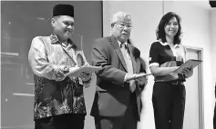  ??  ?? Manyin (centre) presses a notebook to launch CIMB Be$MART programme. Hamidah is on the right.