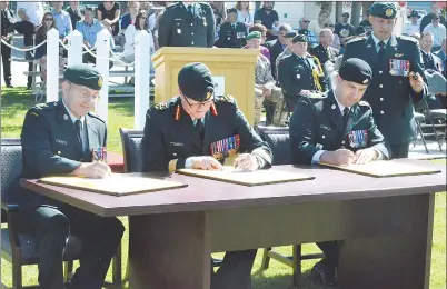  ?? NEWS PHOTO TIM KALINOWSKI ?? Lt. Col. John Scott (left) signs over command of CFB Suffield to Lt. Col. Mike Onieu (right) at the change of command ceremony held Wednesday. Brig. Gen. S.M. Lacroix, commander of 3rd Canadian Division Support Group, signs off on the command change (centre).