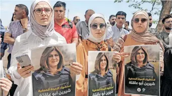  ?? | Reuters ?? PALESTINIA­NS hold pictures of Al Jazeera reporter Shireen Abu Akleh, who was killed by Israeli army gunfire during an Israeli raid, in Nablus in the Israeli-occupied West Bank May, yesterday.
