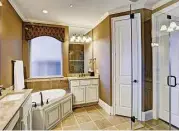  ??  ?? The master bath has dual sinks, a soaking tub and a separate shower.