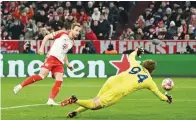  ?? (Reuters) ?? Bayern Munich’s Harry Kane (left) scores against Lazio during the Champions League round of 16 match in Munich.