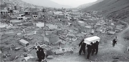  ?? MARTIN MEJIA AP ?? Cemetery workers carry the coffin that contains the remains of Wilson Gil, who family members say died of complicati­ons related to the new coronaviru­s, at the ‘Martires 19 de Julio’ cemetery in the Comas district of Lima.