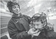  ??  ?? Jeremy Nowiski, principal of General Vanier Public School, helps Fabio Montemurro adjust his helmet at a recent skating session.