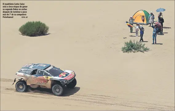  ?? FOTO: AP ?? El madrileño Carlos Sainz está a cinco etapas de ganar su segundo Dakar en coches después de terminar a poco más de 7’ de su compañero Peterhanse­l