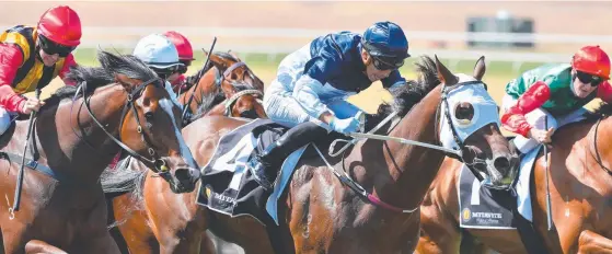  ??  ?? Gold Coast apprentice Jag Guthmann-Chester (blue cap) pushes Heptagon to victory at Sandown in Melbourne. Pictures: GETTY IMAGES