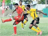  ?? FILE ?? Cuba’s Juan Rodriguez (left) tries to control the ball while under pressure from Jamaica’s Jermaine Lyons (right) during a friendly match in February.