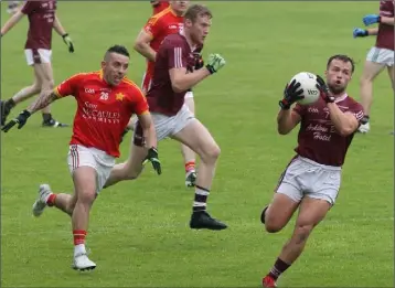  ??  ?? Conor Carty gathers possession for Castletown as Ricky Fox (Starlights) gives chase.