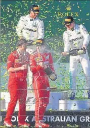  ?? AFP ?? Ferrari's Sebastian Vettel (front right) is bathed in champagne by Lewis Hamilton (back left), and Valtteri Bottas (right).