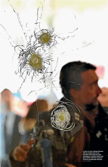  ?? GETTY IMAGES ?? A store on the Champs-Elysees still has bullet holes in its windows following the fatal shooting of a police officer just days before the first round of France’s presidenti­al election.
