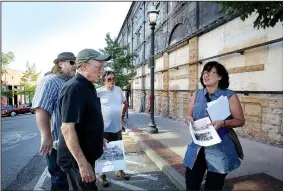  ?? NWA Democrat-Gazette/DAVID GOTTSCHALK ?? Building co-owner Aaron Crawley (from left), architect Albert Skiles, Dan Minkel with Calamon Building Corp., and architect Lisa K.Skiles stand Friday near a section of original facade uncovered on the west facing walls of the former First National Bank building in downtown Fayettevil­le.