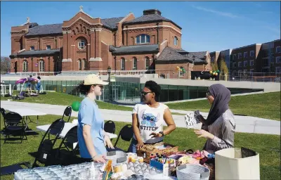  ?? ?? University of St. Thomas students Helen Knudson (from left), Arianna Norals and Salma Nadir set up a table for decorating mason jars and headscarve­s May 7 at the school’s Ramadan celebratio­n on the lawn in front of the Catholic chapel in St. Paul. Many faith leaders across U.S. campuses seek ways to help students manage stress and anxiety.